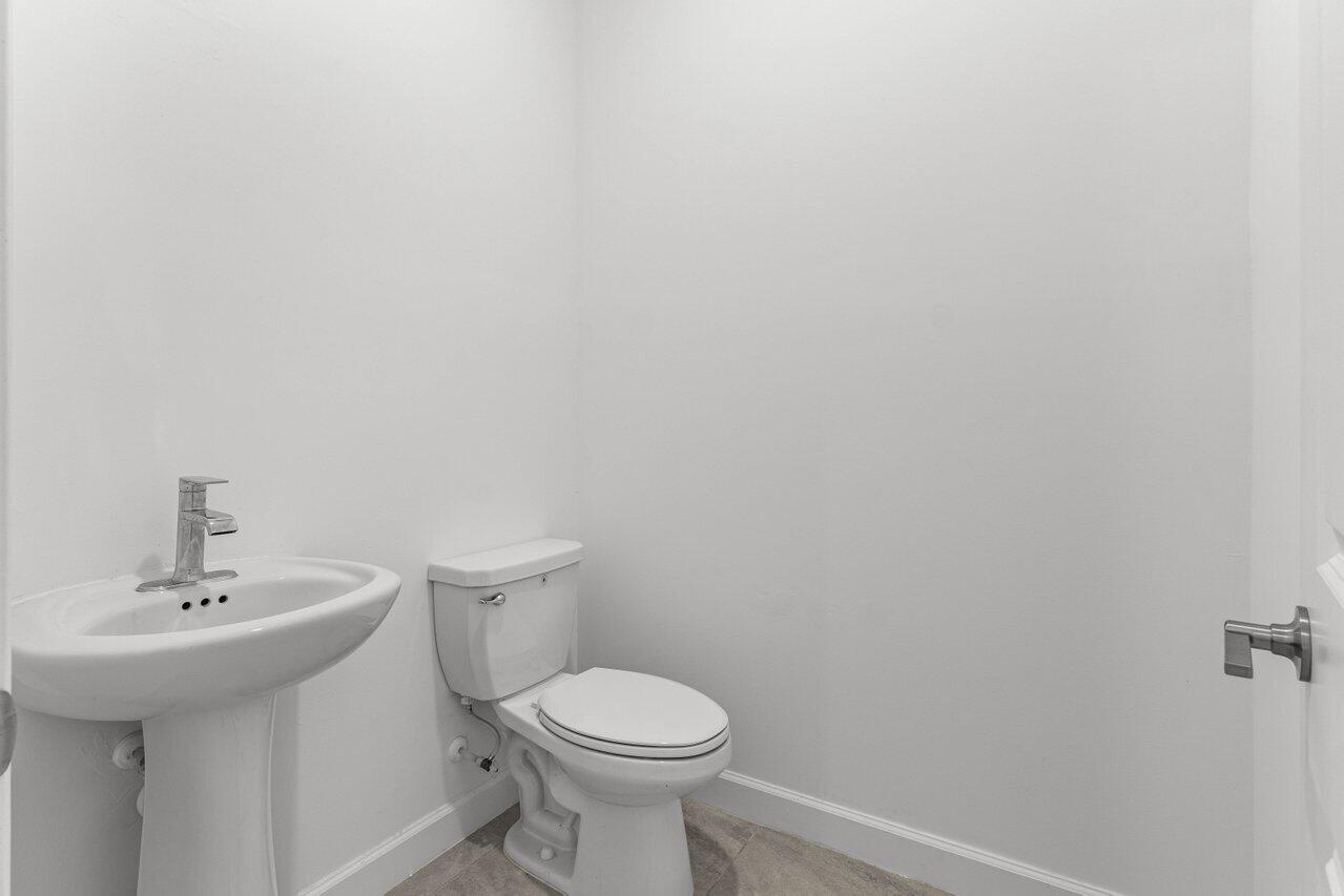 19659 Rugged Trunk Trail Loxahatchee, FL 33470 - Photo 21 of 61 a bathroom with a sink a toilet and a mirror