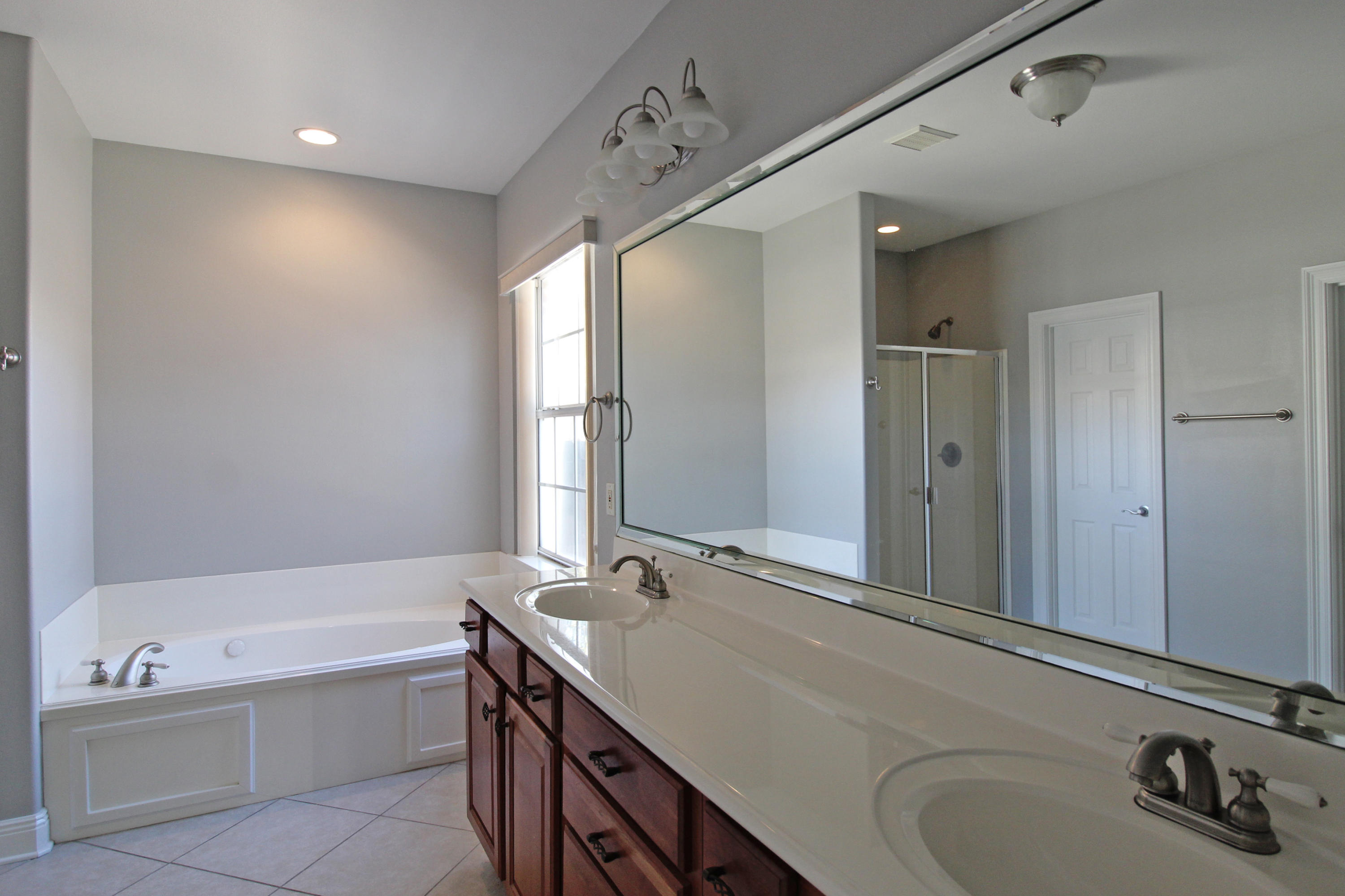 189 Red Maple Way Niceville, FL 32578 - Photo 27 of 58 a bathroom with a tub sink and mirror