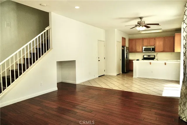 a view of a kitchen with wooden floor a sink a refrigerator and window