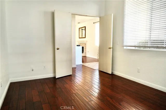 a view of a hallway with wooden floor and a window