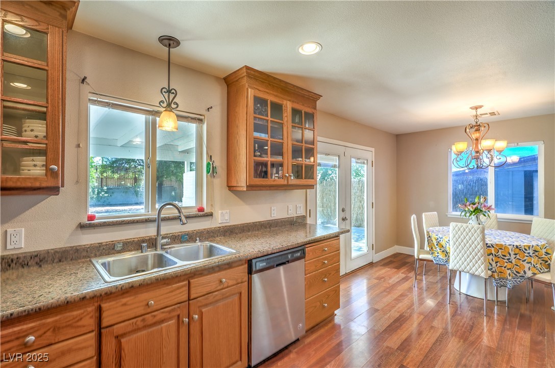 1201 I Boulder City, NV 89005 - Photo 12 of 26 Kitchen featuring brown cabinets, light wood finished floors, dishwasher, pendant lighting, and recessed lighting