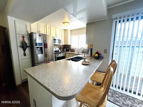 a view of kitchen island with furniture and refrigerator