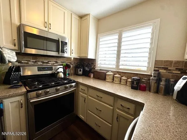 a kitchen with stainless steel appliances a stove a microwave and cabinets