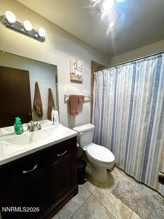 a bathroom with a double vanity sink toilet and a mirror