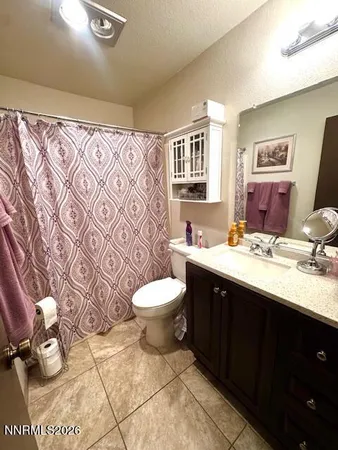 a spacious bathroom with a toilet sink and mirror