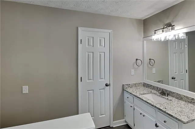 a bathroom with a granite countertop sink a toilet and shower