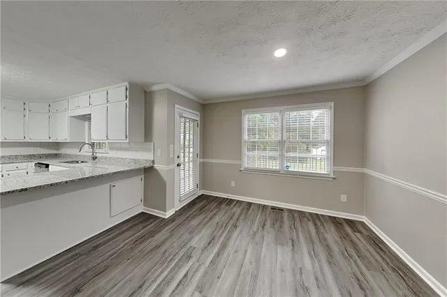 a view of a kitchen with wooden floor and electronic appliances