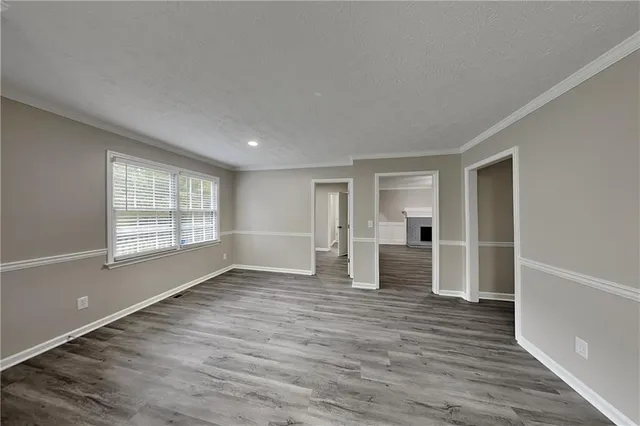 a view of empty room with wooden floor and window