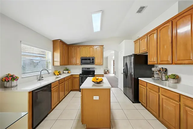 a kitchen with stainless steel appliances a refrigerator sink stove microwave and cabinets