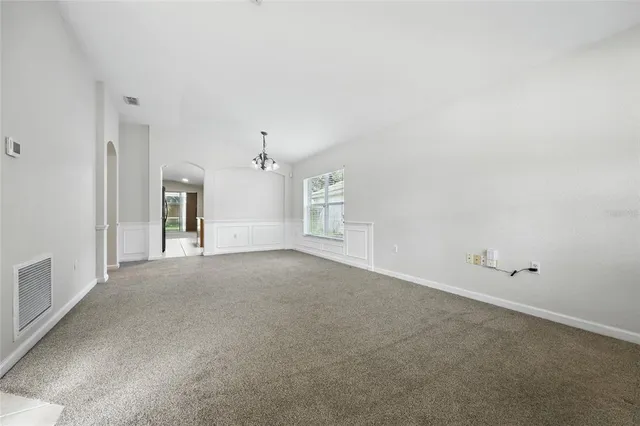 a view of a big room with chandelier fan and windows