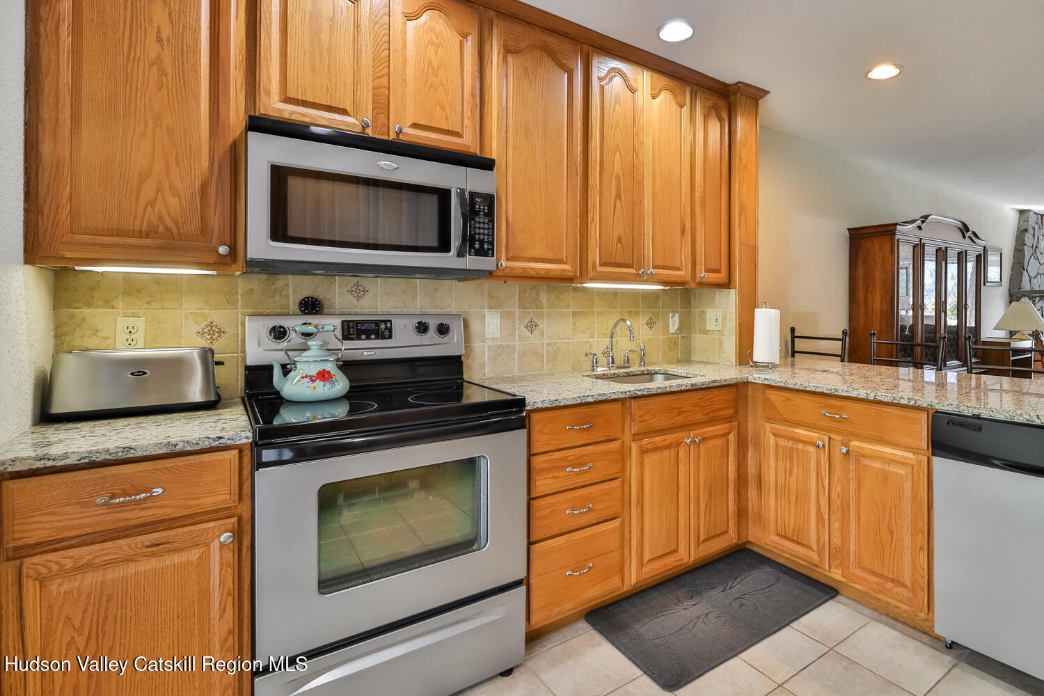33 Scribner Hollow Road, Unit E4 Hunter, NY 12442 - Photo 12 of 44 a kitchen with granite countertop a stove top oven microwave and cabinets