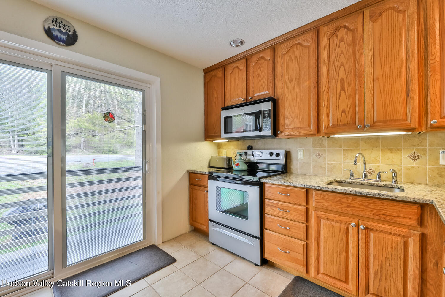 33 Scribner Hollow Road, Unit E4 Hunter, NY 12442 - Photo 14 of 44 a kitchen with stainless steel appliances granite countertop a stove a sink dishwasher and a refrigerator with wooden cabinets