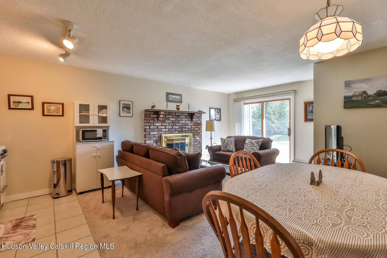 33 Scribner Hollow Road, Unit E4 Hunter, NY 12442 - Photo 32 of 44 a living room with furniture a chandelier and a dining table