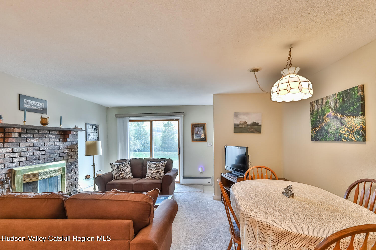 33 Scribner Hollow Road, Unit E4 Hunter, NY 12442 - Photo 33 of 44 a living room with furniture a fireplace and a chandelier