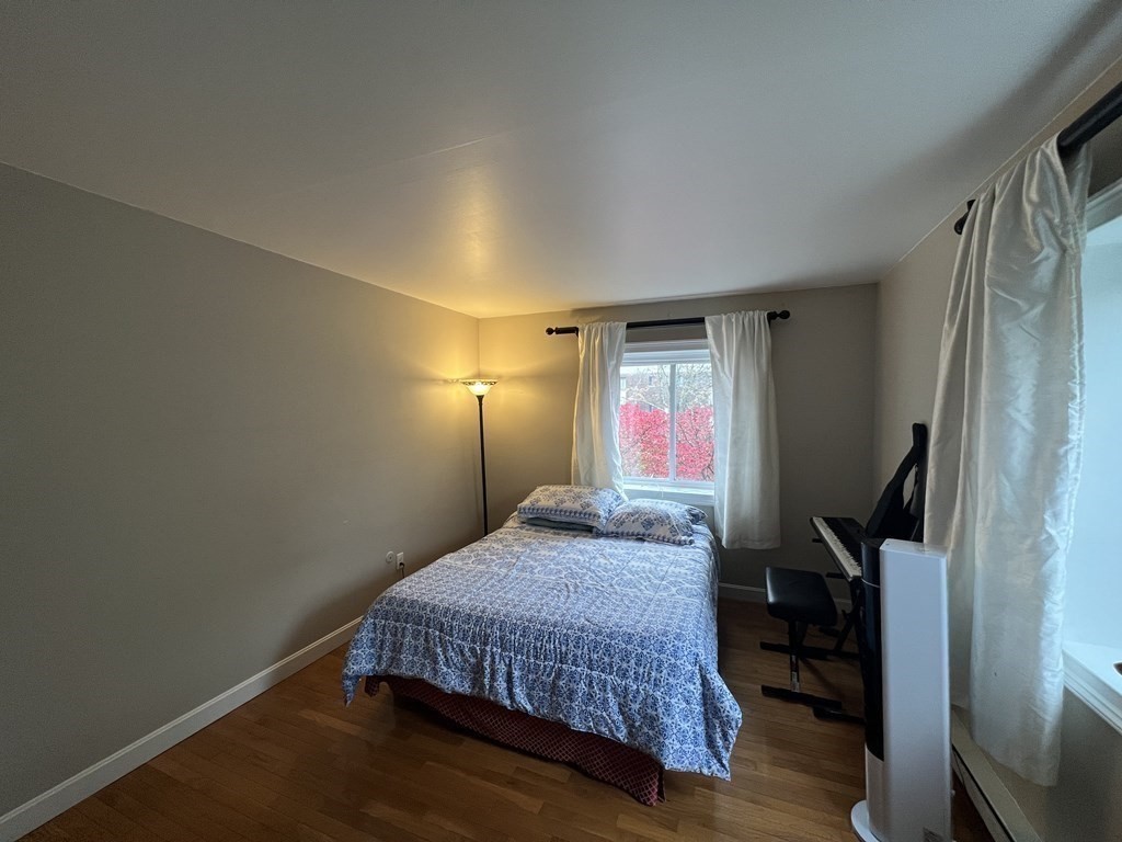 1 Universal Street, Unit 7 Framingham, MA 01702 - Photo 11 of 23 a bedroom with a bed and wooden floor