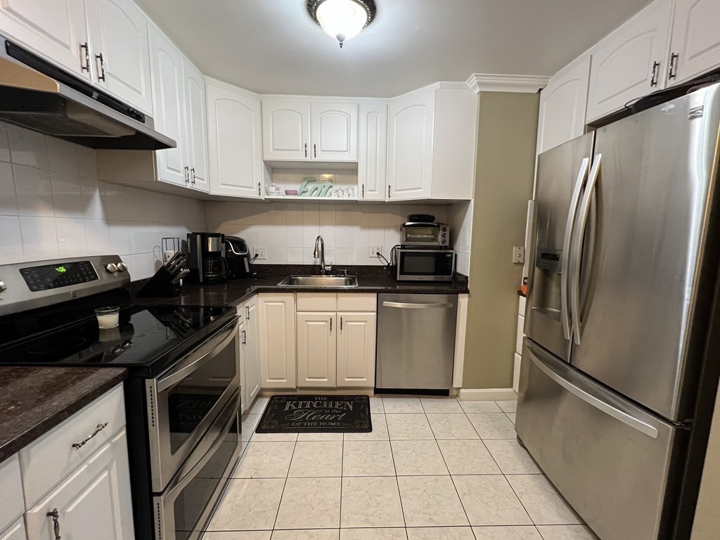 1 Universal Street, Unit 7 Framingham, MA 01702 - Photo 6 of 23 a kitchen with a refrigerator sink and cabinets