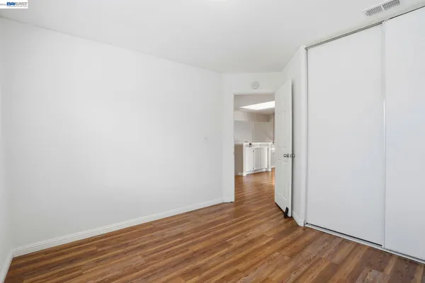 a view of a room with wooden floor and a hallway