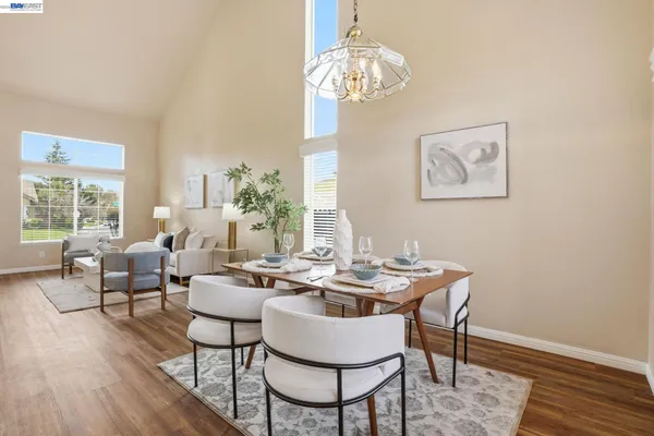 a dining room with wooden floor a chandelier a wooden table and chairs