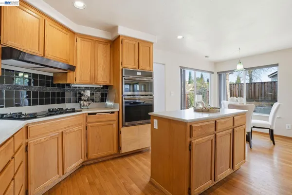 a kitchen with stainless steel appliances granite countertop a stove and cabinets