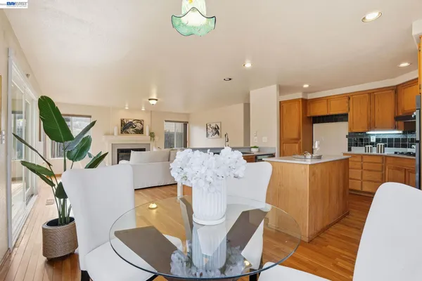 a living room with furniture a chandelier and kitchen view
