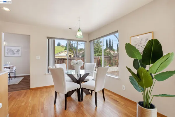 a dining room with furniture potted plants and wooden floor