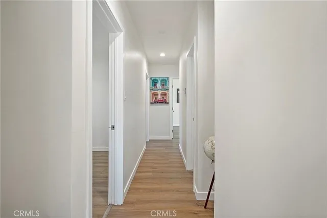 a view of a hallway with wooden floor and stairs