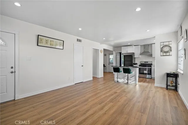 a view of kitchen with stainless steel appliances refrigerator oven and chairs