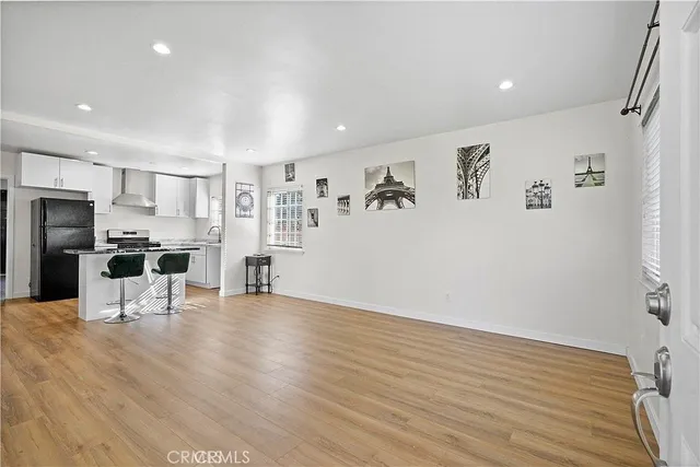 a view of a kitchen with furniture and wooden floor