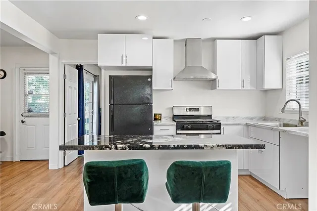 a kitchen with stainless steel appliances granite countertop a stove a sink and a refrigerator