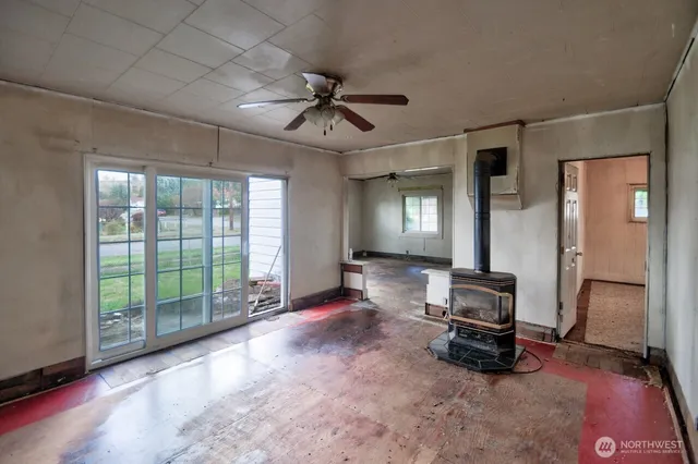 a view of empty room with wooden floor and ceiling fan