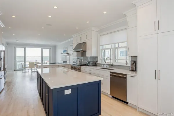 a kitchen with a sink a counter top space stainless steel appliances and cabinets