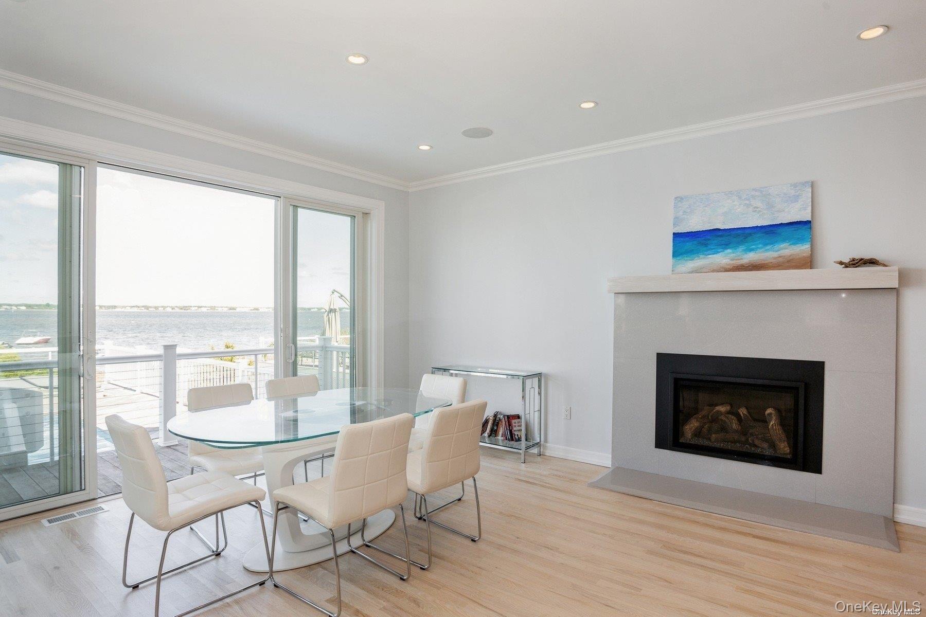 676 Dune Road West Hampton Dunes, NY 11978 - Photo 6 of 20 a dining room with furniture a fireplace and wooden floor