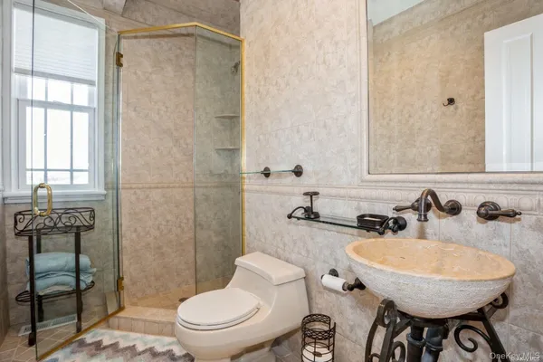 a bathroom with a sink a toilet and shower