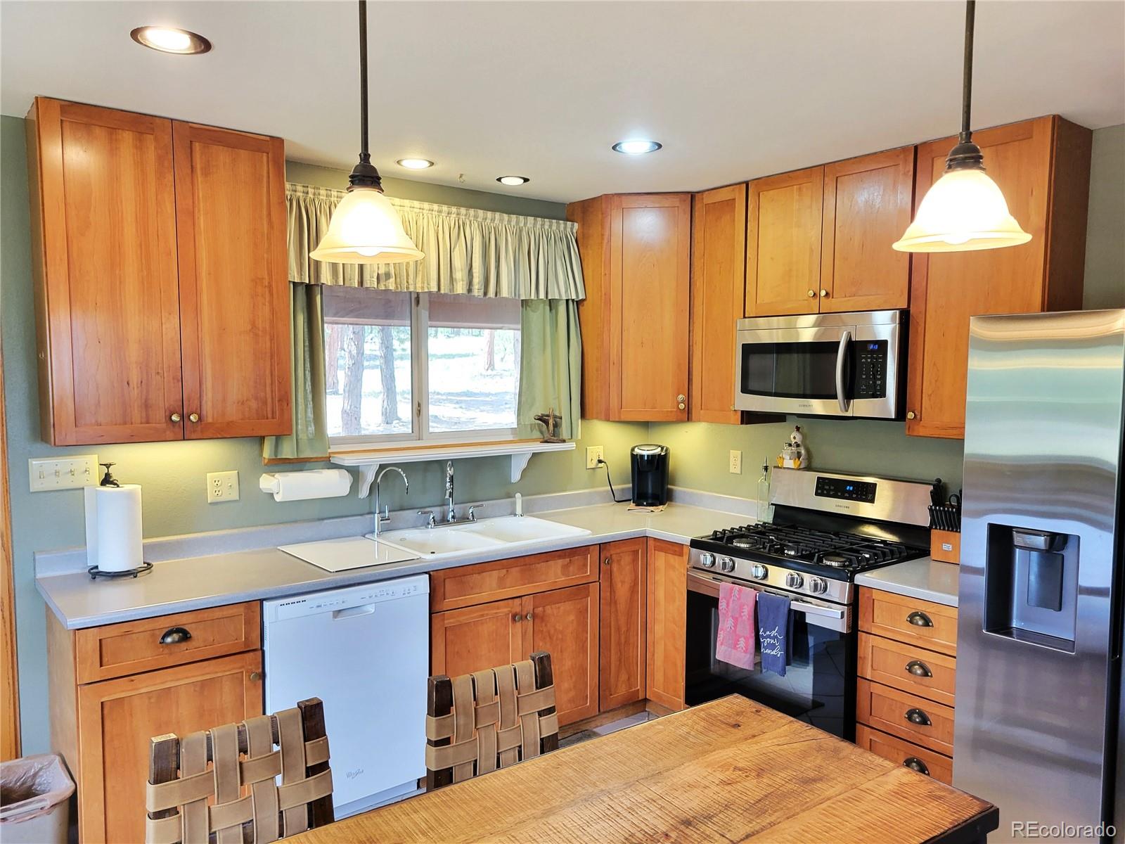 5076 Campfire Road Hartsel, CO 80449 - Photo 6 of 35 a kitchen with stainless steel appliances granite countertop a sink a stove a refrigerator cabinets and wooden floor