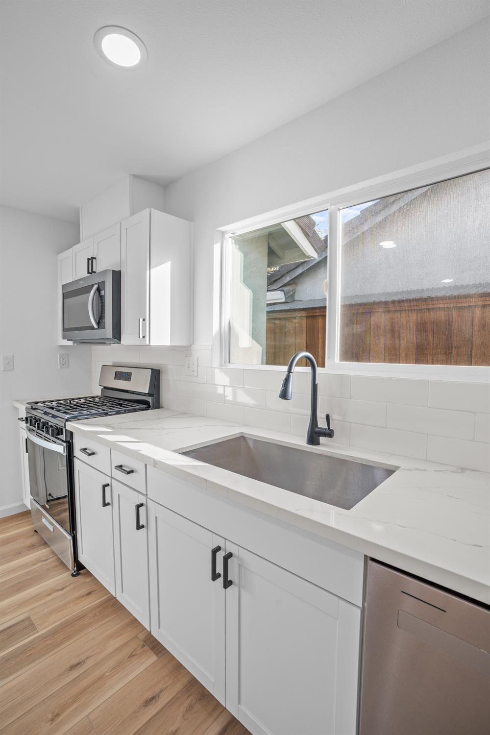 1509 Boothe Road Ceres, CA 95307 - Photo 14 of 28 a kitchen with white cabinets appliances and a sink