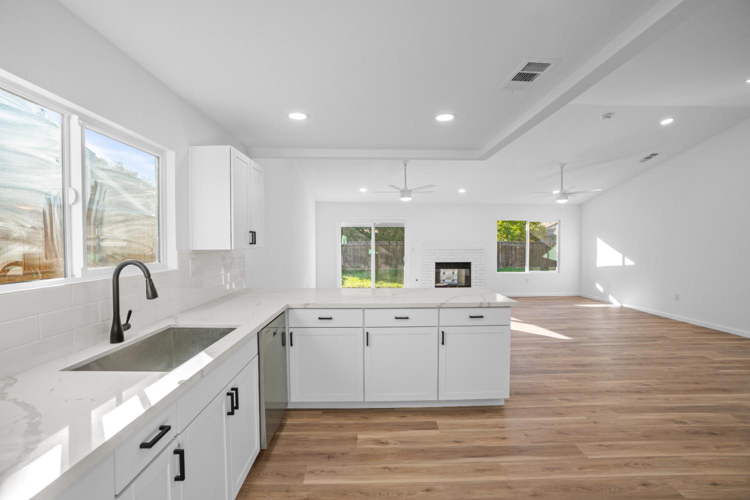 1509 Boothe Road Ceres, CA 95307 - Photo 15 of 28 a large white kitchen with wooden floors and white walls