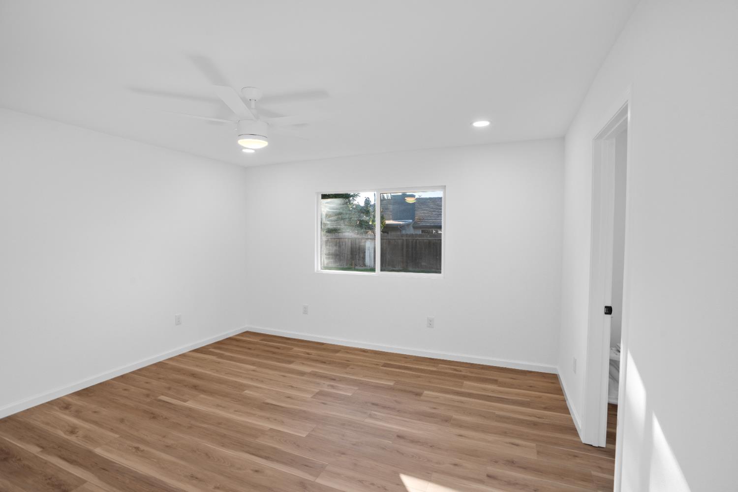 1509 Boothe Road Ceres, CA 95307 - Photo 17 of 28 a view of empty room with wooden floor and fan
