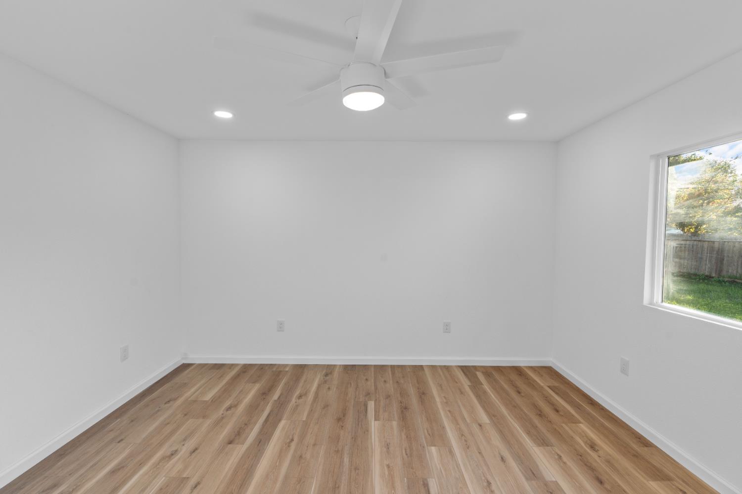 1509 Boothe Road Ceres, CA 95307 - Photo 20 of 28 an empty room with wooden floor and windows