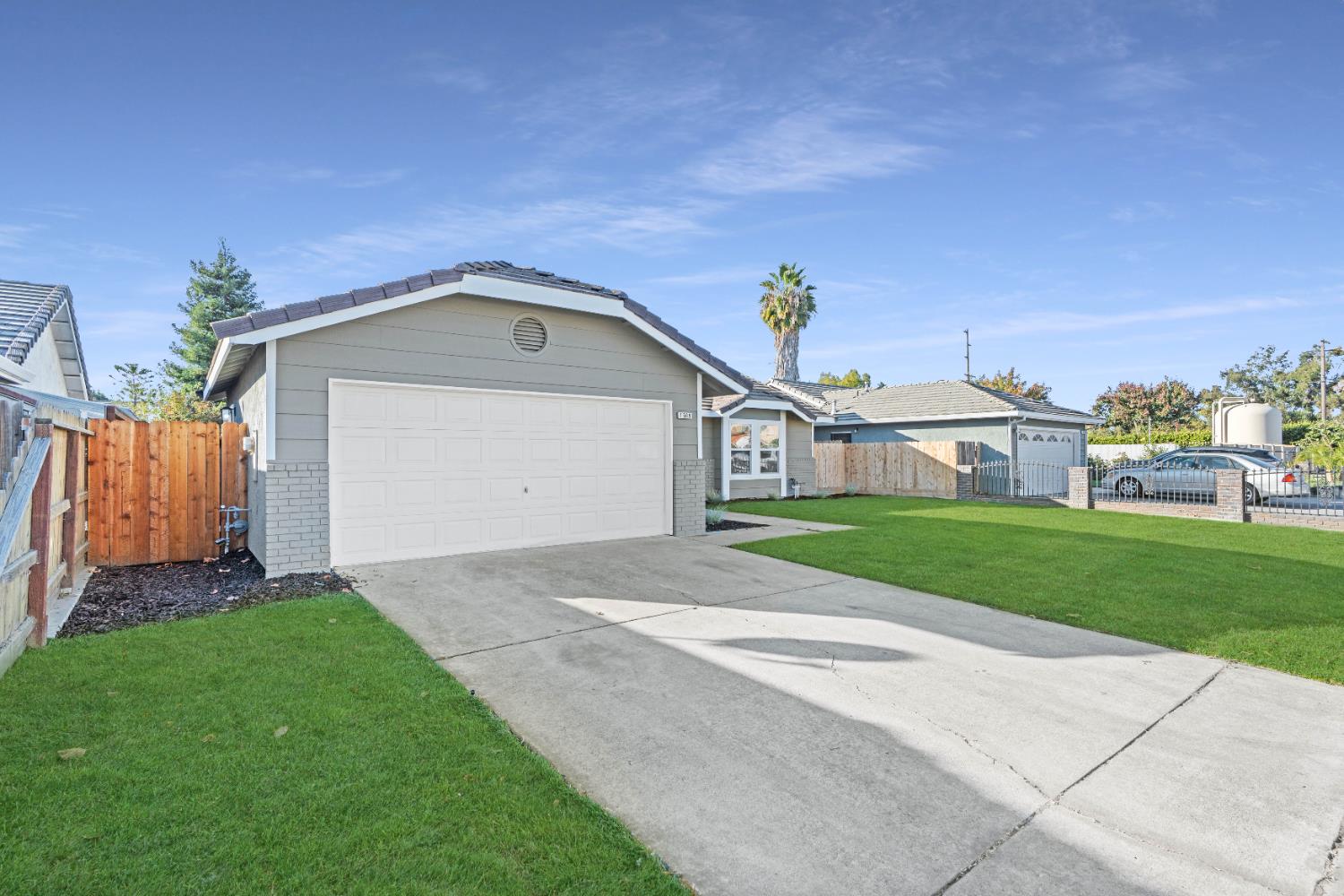 1509 Boothe Road Ceres, CA 95307 - Photo 2 of 28 a front view of a house with a yard and garage