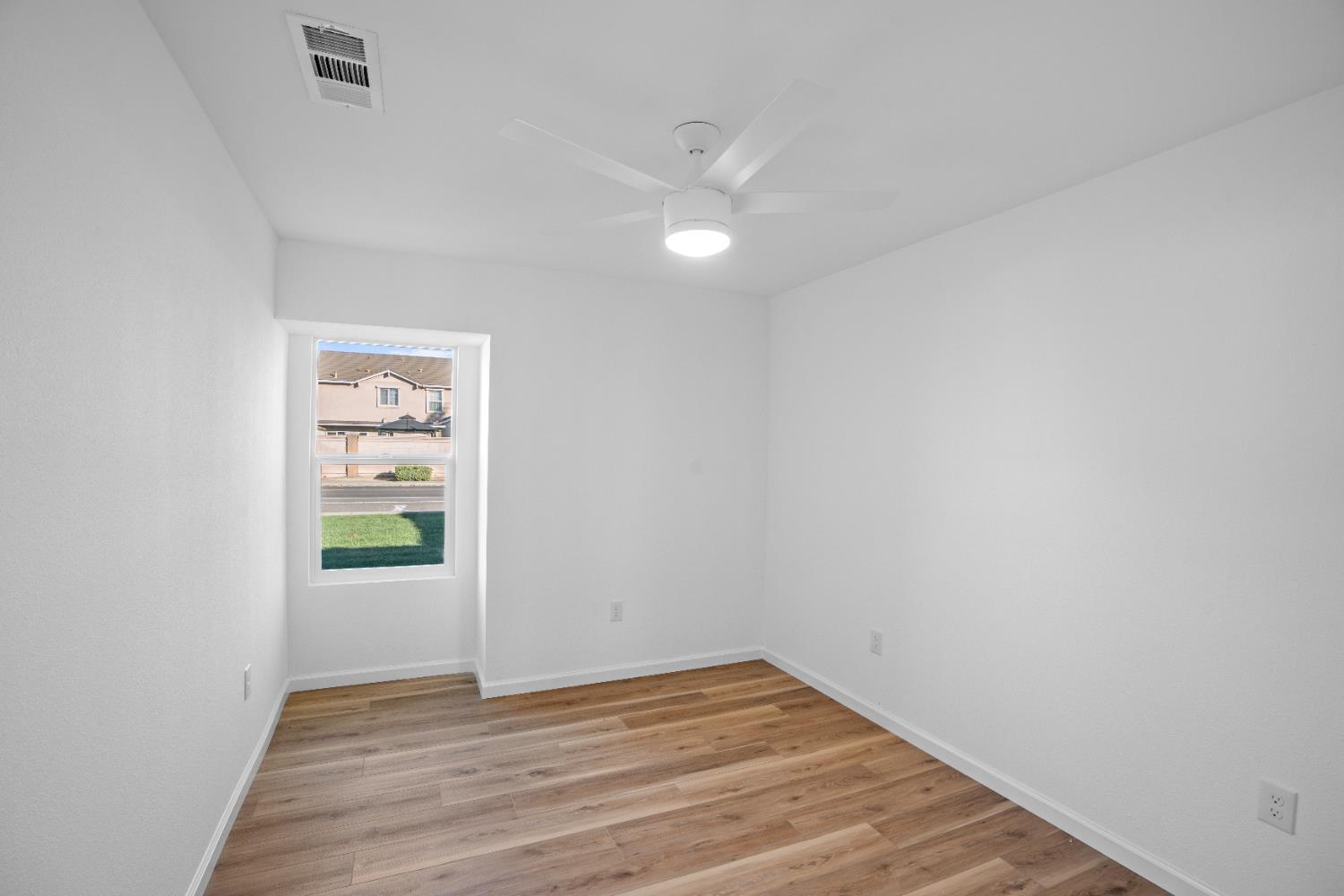 1509 Boothe Road Ceres, CA 95307 - Photo 23 of 28 a view of an empty room with wooden floor and a window