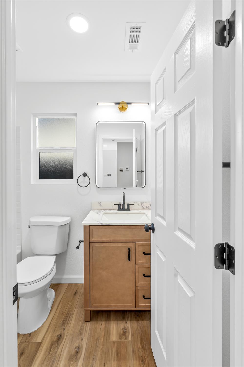 1509 Boothe Road Ceres, CA 95307 - Photo 24 of 28 a spacious bathroom with a granite countertop sink toilet a mirror and shower