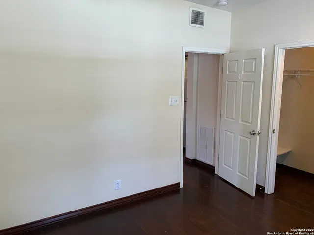 an empty room with wooden floor and closet area