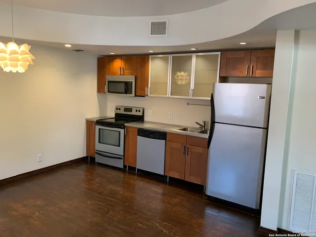a kitchen with stainless steel appliances granite countertop a refrigerator a sink and a stove