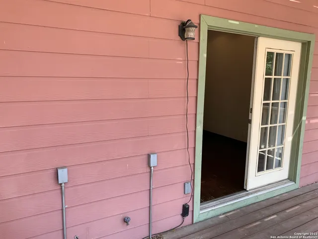 an empty room with wooden floor and a hallway
