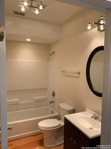 a bathroom with a sink a toilet and a mirror