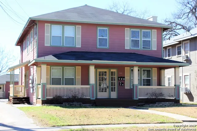 a view of a brick house with many windows and a yard