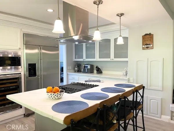 a kitchen with stainless steel appliances kitchen island granite countertop a dining table and chairs