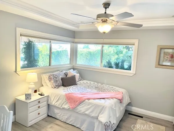 a bedroom with a large bed and a chandelier fan