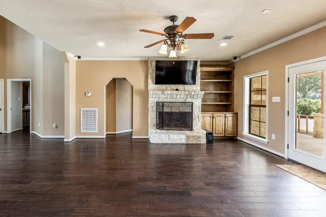 a view of a livingroom with wooden floor and a ceiling fan