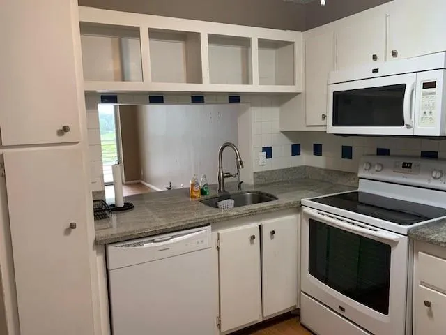 a kitchen with stainless steel appliances granite countertop a sink and a microwave